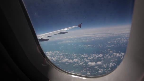 View of the blue sky and clouds through the window of the aircraft, Close up Airplane window with airplane wing, Traveling concept — Stock Video