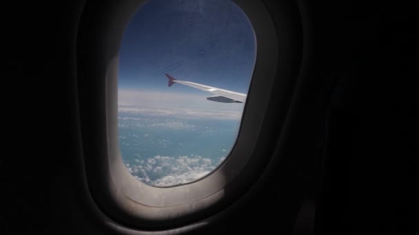 Vista del cielo blu e delle nuvole attraverso il finestrino dell'aereo, Close up Finestrino dell'aereo con ala dell'aereo, Concetto di viaggio — Video Stock