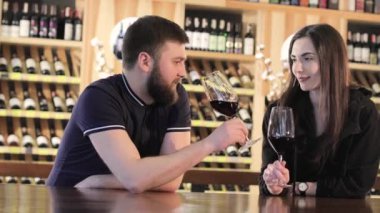 Bir kız ve bir adam bir restoranda iletişim ve kırmızı şarap içmek, Genç bir çift kırmızı şarap içecekler barda bir masada bir restoran veya kafe, dinlenme