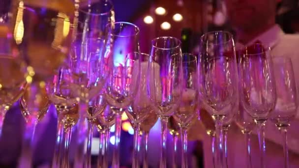 Официант наливает шампанское в бокалы, бокалы с шампанским на стол в ресторане, бокалы шампанского на праздничный стол, чистые бокалы на стол, приготовленный барменом для шампанского — стоковое видео