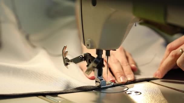 Mujer que trabaja en una máquina de coser, máquina de coser aguja, manos femeninas, máquina de coser industrial — Vídeo de stock