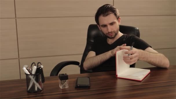 Empresario tomando notas con fondo portátil. Empresario escribiendo en un cuaderno en una mesa. Concepto empresarial — Vídeo de stock