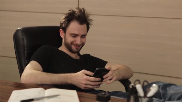 Mannen reagerar känslomässigt på notifieringar i telefonen, kontorist gläds över vad som händer på telefonskärmen — Stockvideo