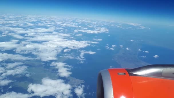 Beautiful view from the airplane window to the blue sky and white clouds, white clouds float above the ground — Stock Video