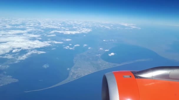 飛行機の窓から青い空と白い雲、美しい景色、地面上に浮いている白い雲 — ストック動画