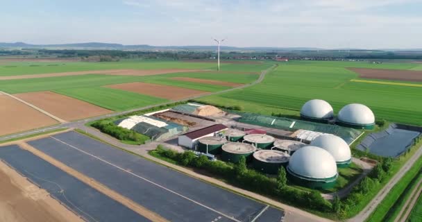 Impianto per la produzione di biogas in campo verde, impianto per la produzione di biogas sullo sfondo dei generatori eolici vista dall'alto — Video Stock