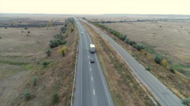 Autopista fuera de la ciudad vista panorámica desde arriba, carretera a lo largo del campo, los coches se van, la motocicleta se mueve a lo largo de la carretera, el tráfico — Vídeos de Stock