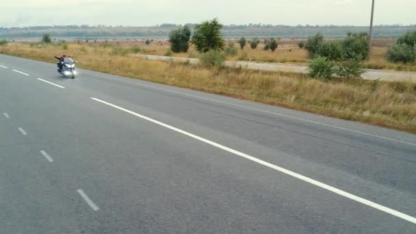 Kívül a város közelről, autópálya mentén a területen, a Highway autók mennek, motorkerékpár mozog út mentén, forgalom — Stock videók