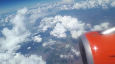 Uçak penceresinden görüntülemek için mavi gökyüzü ve beyaz bulutlar, bir turuncu türbin kanat uçağın gökyüzünde bulutlar, beyaz bulutlar float yerden dünyadan bir görünümünü