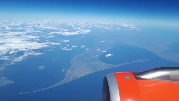 Mooie uitzicht uit het raam van het vliegtuig aan de blauwe hemel en witte wolken, witte wolken zweven boven de grond — Stockvideo