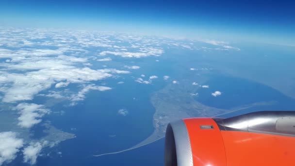 Mooie uitzicht uit het raam van het vliegtuig aan de blauwe hemel en witte wolken, witte wolken zweven boven de grond — Stockvideo