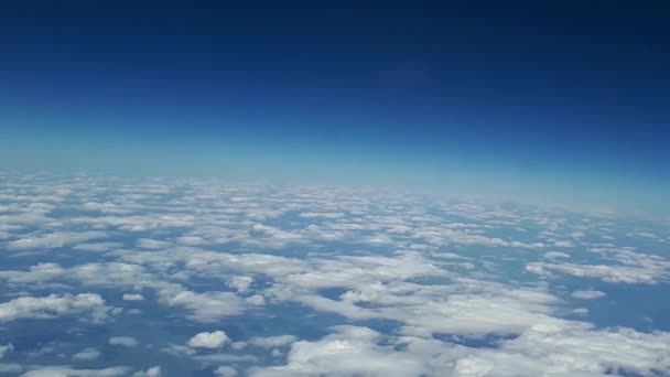 Όμορφη θέα από το παράθυρο του αεροπλάνου προς τον μπλε ουρανό και άσπρα σύννεφα, σύννεφα λευκό επιπλέουν πάνω από το έδαφος — Αρχείο Βίντεο