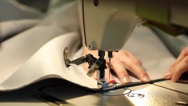 Mujer que trabaja en una máquina de coser, máquina de coser aguja, manos femeninas, video de cámara lenta, primer plano, profundidad de campo poco profunda, máquina de coser industrial — Vídeos de Stock