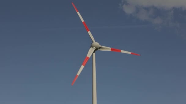 Turbina eólica de primer plano sobre el fondo de nubes flotando en el cielo. Rotación de grandes palas de aerogeneradores de cerca. Día soleado — Vídeo de stock