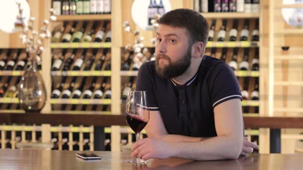 Samotny mężczyzna przy lampce czerwonego wina, młody człowiek w restauracji przy lampce czerwonego wina, człowiek pije wino czerwone do stolika w restauracji — Wideo stockowe