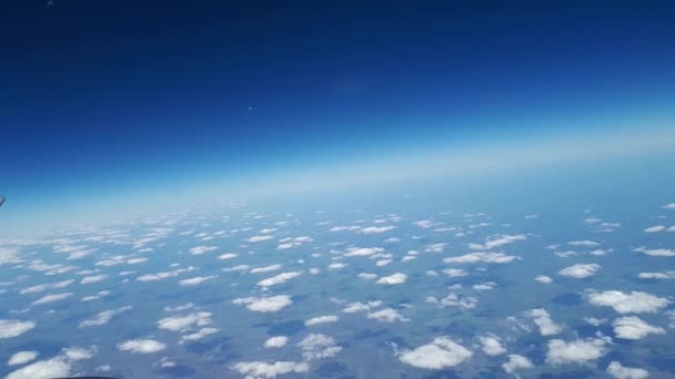 飛行機の窓から青い空と白い雲、美しい景色、地面上に浮いている白い雲 — ストック動画