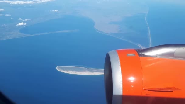 Mooie uitzicht uit het raam van het vliegtuig aan de blauwe hemel en witte wolken, witte wolken zweven boven de grond — Stockvideo