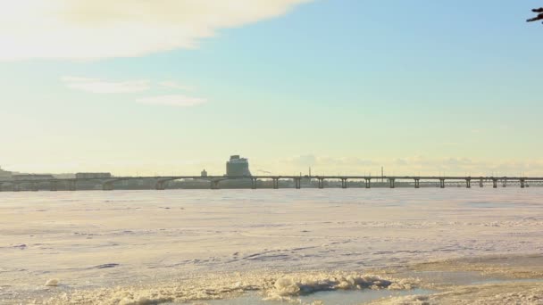 Panorama da cidade perto do rio no inverno, uma cidade com edifícios altos perto do rio. O rio congelado perto da cidade grande uma metrópole de inverno — Vídeo de Stock
