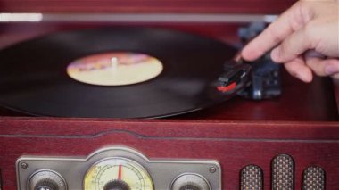 Retro bir pikap, bir vinil oyuncunun oynadığı bir adam bir vinil oyuncu dönüyor