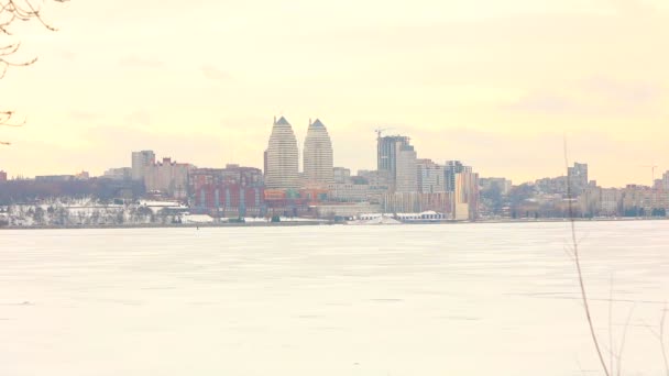 Panorama van de stad in de buurt van de rivier in de winter, een stad met hoge gebouwen in de buurt van de rivier, een plaats (city) in de winter, een winter-metropool — Stockvideo