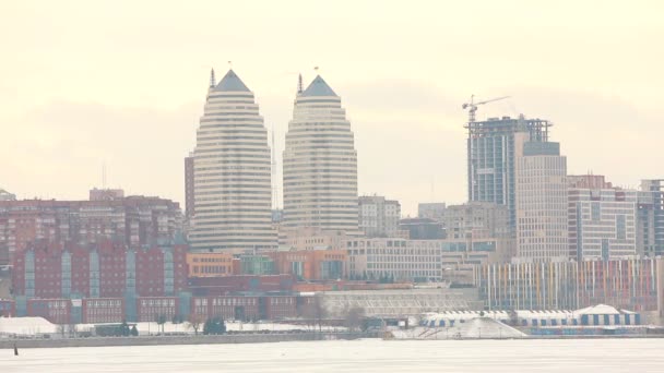 Panorama miasta, w pobliżu rzeki w zimie, miasta z wysokich budynków w pobliżu rzeki, miasto w zimie, metropolia zima — Wideo stockowe