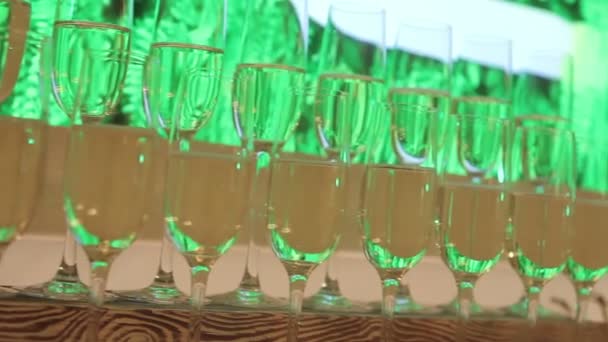 Ett glas champagne på bakgrunden av tomma glas, på buffébordet, Champagne skum i ett glas, kamerarörelser, ett glas champagne i förgrunden, Champagne på glas glasögon — Stockvideo