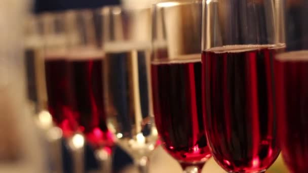 Copas con bebidas alcohólicas, copas de vino y champán están en la mesa buffet, vino tinto en copas, champán junto a la copa, mesa buffet con alcohol en un restaurante, Año Nuevo, Navidad — Vídeo de stock