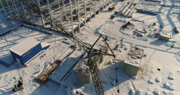 Construcción de una fábrica o planta moderna, zona industrial en invierno, vista panorámica desde el aire. Moderna planta en el campo cubierto de nieve, la estructura de acero estructural de un nuevo edificio comercial — Vídeo de stock