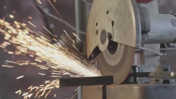 Metallsäge schneidet dünnes Vierkantrohr, orangefarbene Funken aus Metallsäge — Stockvideo