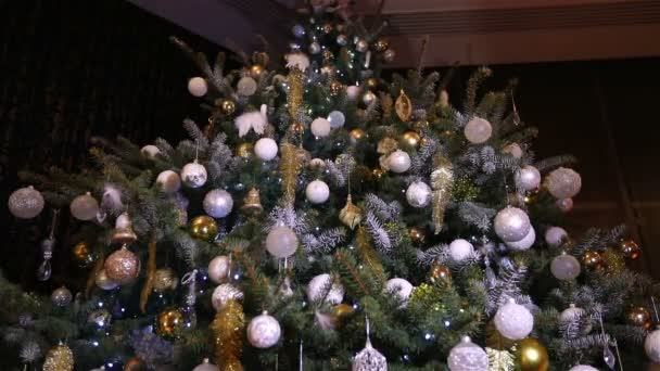Bola de Natal, luzes de Natal penduradas em uma árvore, Ano Novo, bugiganga de prata pendurada em uma árvore de Natal decorada — Vídeo de Stock
