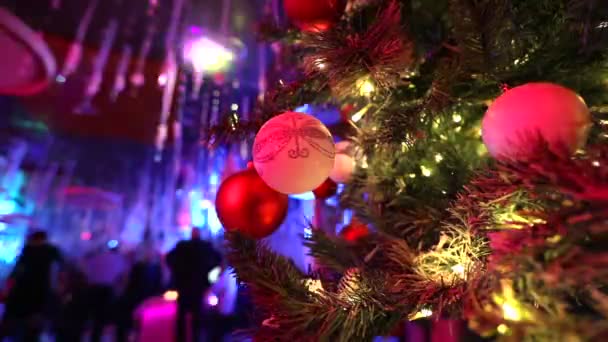 Рождественская дискотека в ресторане, елка на фоне дискотеки, танцующие силуэты людей, световые лучи,, елка с игрушками, банкет — стоковое видео