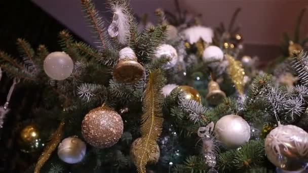 Christmas ball, christmas lights hanging in a tree, New Year, silver bauble hanging from a decorated Christmas tree — Stock Video