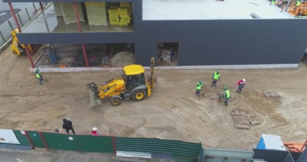 Grävmaskin på byggarbetsplats, personer arbetar på byggarbetsplats — Stockvideo