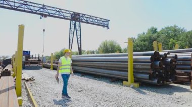 Depo çalışanı metalin envanterini çıkarıyor. Yönetici ürün sayısını sayar