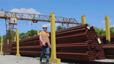 Bir depo çalışanı deftere not alır. Depo çalışanı metalin envanterini çıkarıyor. Yönetici ürün sayısını sayar