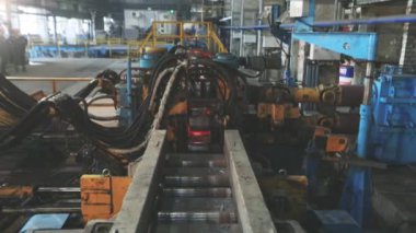Metalürji. Sıcak Metal Tüpler. Sıcak çelik boru üretim hattı. Kırmızı sıcak metal boru üretim süreci.