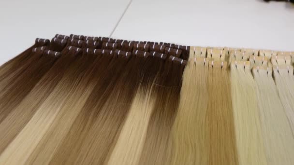 Long beaux cheveux féminins, artificiels longs cheveux féminins dans des tons clairs — Video