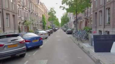 Amsterdam 'da bir kadın bisiklet sürüyor. Amsterdam 'da bisikletli bir kız.