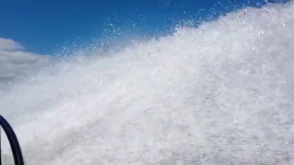 Stor spray från en motorbåt. En motorbåt simmar snabbt i havet och skapar stora stänk — Stockvideo