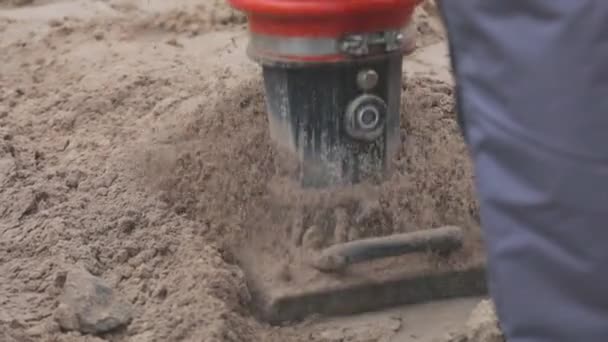 Tampar a placa vibratória do solo. Batendo no rammer. Fluxo de trabalho de construção — Vídeo de Stock