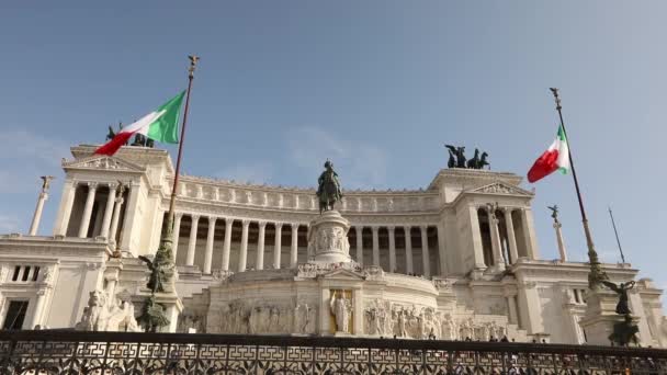 Flaggen Italiens flattern im Wind. Platz von Venedig in Rom. Touristen in der Nähe des Denkmals für Viktor Emanuel II — Stockvideo