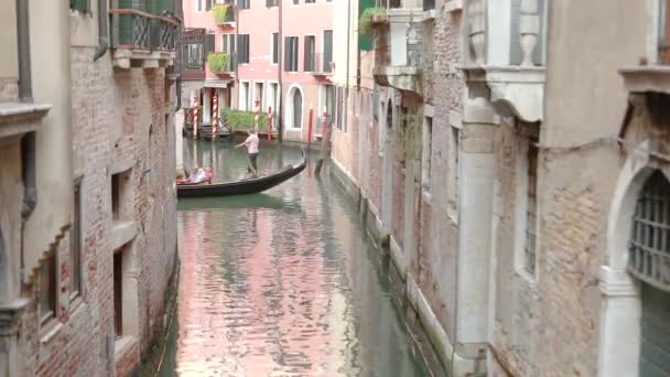 Gondola con turisti in un bellissimo stretto canale di Venezia. Bellissimo canale veneziano. Gondolier guida i turisti Venezia, Italia. Luogo romantico Venezia — Video Stock