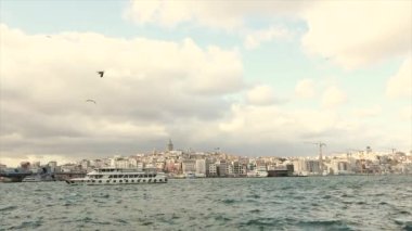 İstanbul 'da rüzgarlı bir gün. Zevk tekneleri Boğaz 'da yüzer, Galata Kulesi ise arka planda.