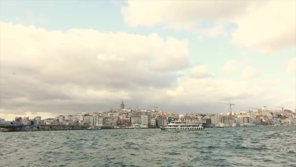 En blåsig dag i Istanbul. Fritidsbåtar flyter på Bosporen, Galata Tower i bakgrunden — Stockvideo