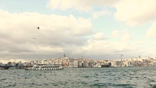 En blåsig dag i Istanbul. Fritidsbåtar flyter på Bosporen, Galata Tower i bakgrunden — Stockvideo