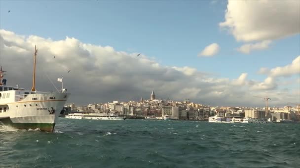 Torre Galata, in primo piano imbarcazioni da diporto con turisti e gabbiani. Barche da diporto sullo sfondo della Torre di Galata, tempo ventoso — Video Stock