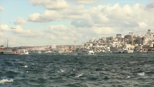 船在城市的背景下漂浮在海湾里.金角湾的船只移动。土耳其伊斯坦布尔。2019年4月10日 — 图库视频影像