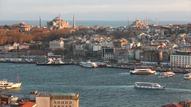 Matahari sore menyinari Masjid Biru dan Hagia Sophia. Sebuah bingkai lebar dari katedral-katedral dan selat Tanduk Emas di malam hari pada jam emas — Stok Video