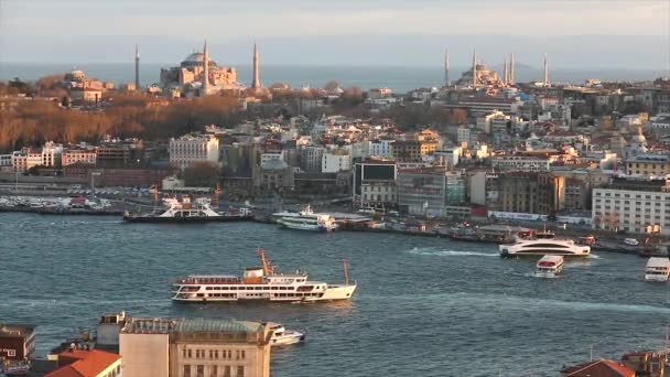 De avondzon verlicht de Blauwe Moskee en Hagia Sophia. Een breed kader van Istanbuls kathedralen en de Gouden Hoorn zeestraat in de avond op het gouden uur — Stockvideo