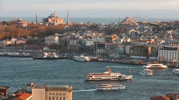 A wide frame of Istanbuls cathedrals and the Golden Horn strait in the evening at the golden hour. The evening sun illuminates the Blue Mosque and Hagia Sophia. April 10, 2019 — Stock Video